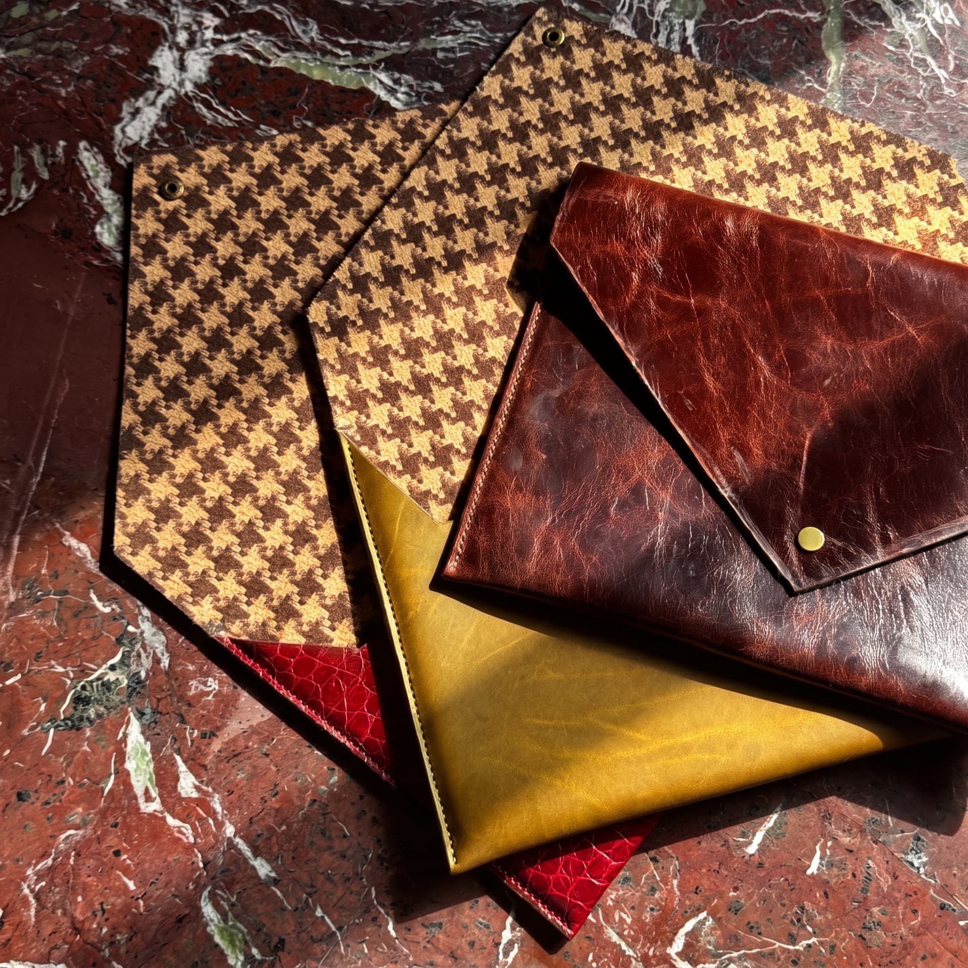 MacLeather leather envelopes arranged on a marble table